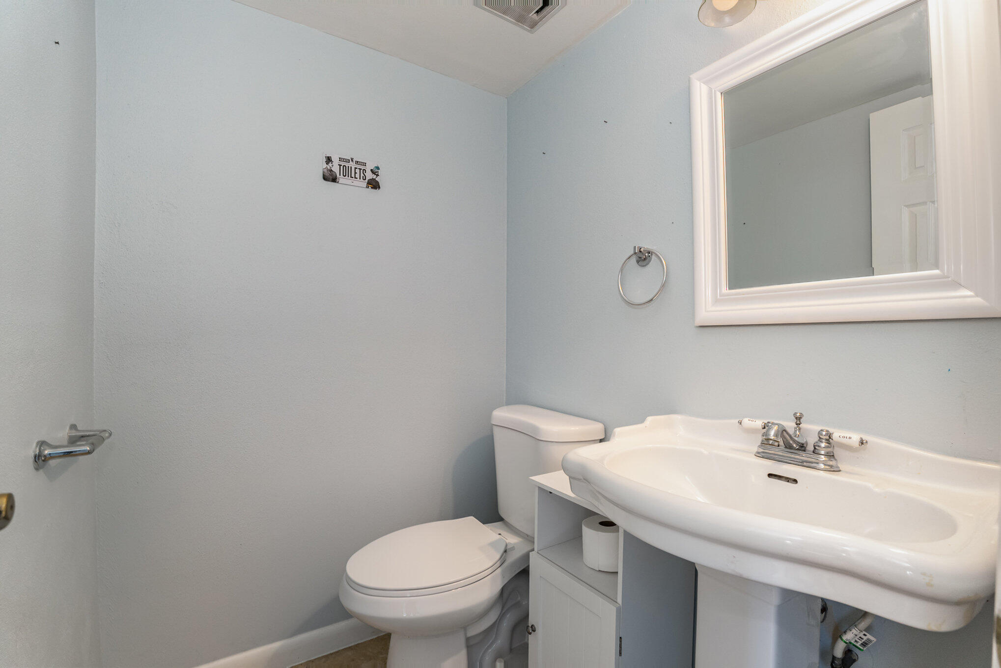 3118 Manor Drive Northeast Palm Bay, FL 32905 - Photo 18 of 22 a bathroom with a sink a toilet and mirror
