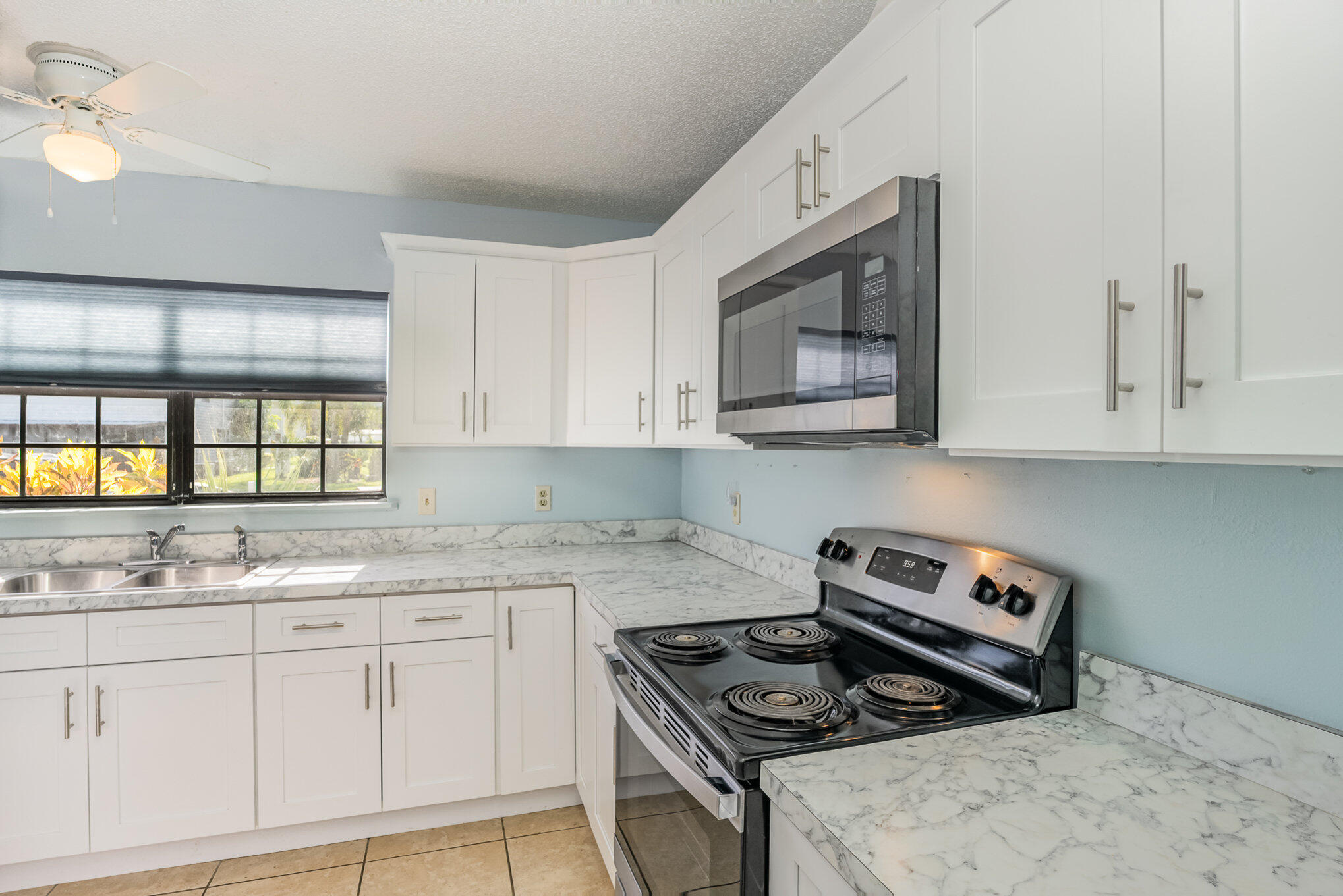 3118 Manor Drive Northeast Palm Bay, FL 32905 - Photo 2 of 22 a kitchen with stainless steel appliances granite countertop white cabinets and window