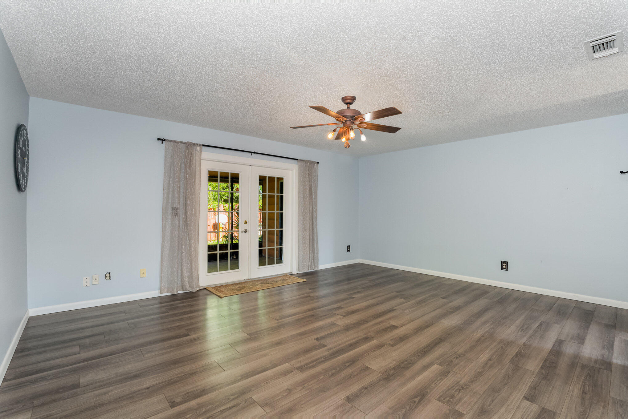 3118 Manor Drive Northeast Palm Bay, FL 32905 - Photo 9 of 22 wooden floor in an empty room with a window