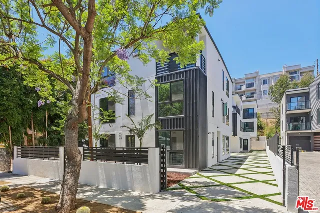 a front view of a house with a tree