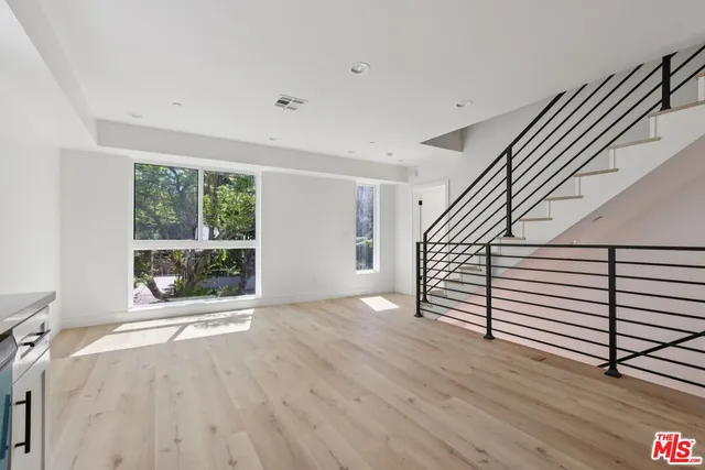 a view of a kitchen with wooden floor and electronic appliances
