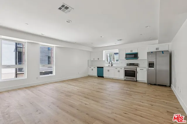 a kitchen with stainless steel appliances a refrigerator and a stove top oven
