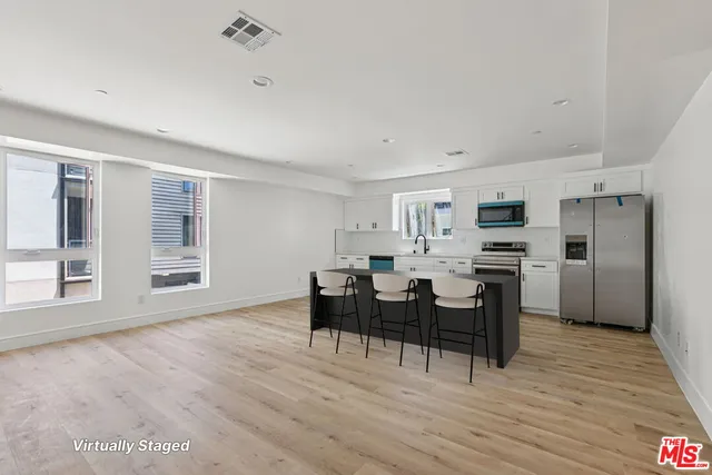 a view of a kitchen with stainless steel appliances cabinets and wooden floor