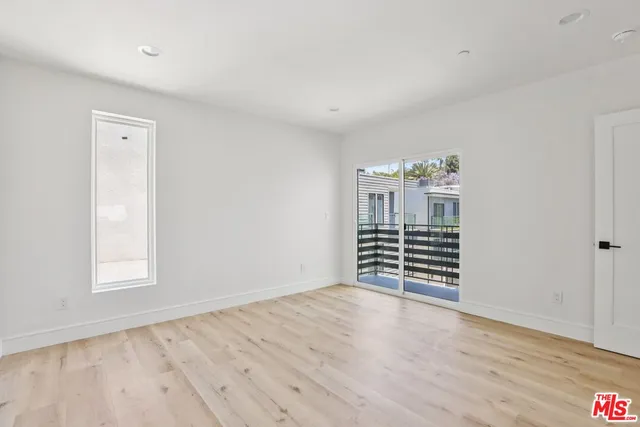 a view of a hallway with wooden floor and stairs