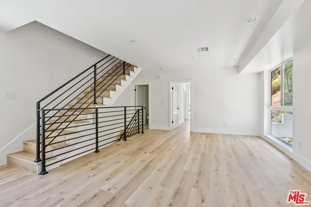a view of a kitchen with wooden floor and stairs