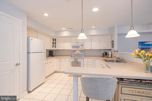 a kitchen with a sink and chairs