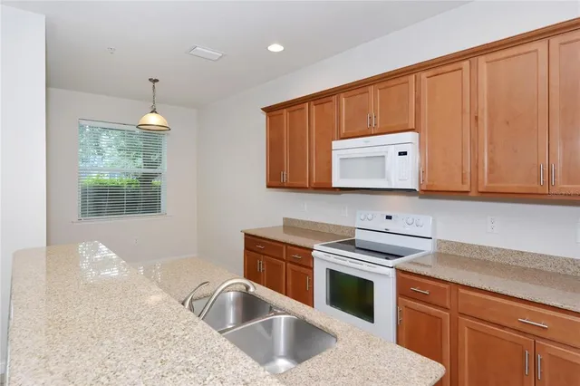 a kitchen with granite countertop a sink cabinets and window