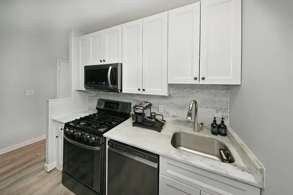 a kitchen with white cabinets and a stove top oven