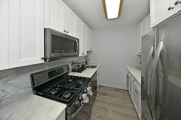 a kitchen with stainless steel appliances a stove a microwave and a refrigerator