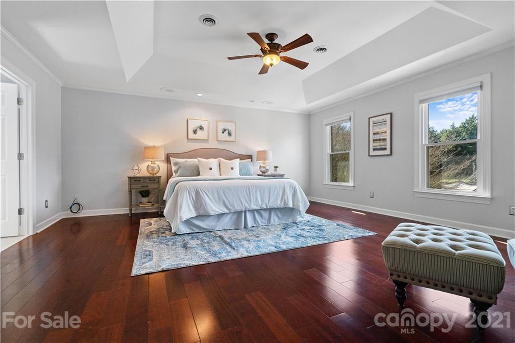 8866 Collins Road Indian Land, SC 29707 - Photo 18 of 48 a bedroom with a large bed and a chandelier