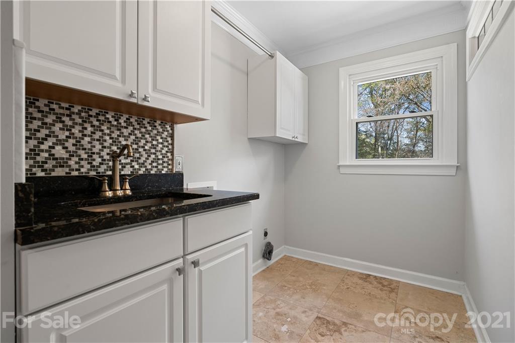 8866 Collins Road Indian Land, SC 29707 - Photo 30 of 48 a kitchen with granite countertop white cabinets and black appliances