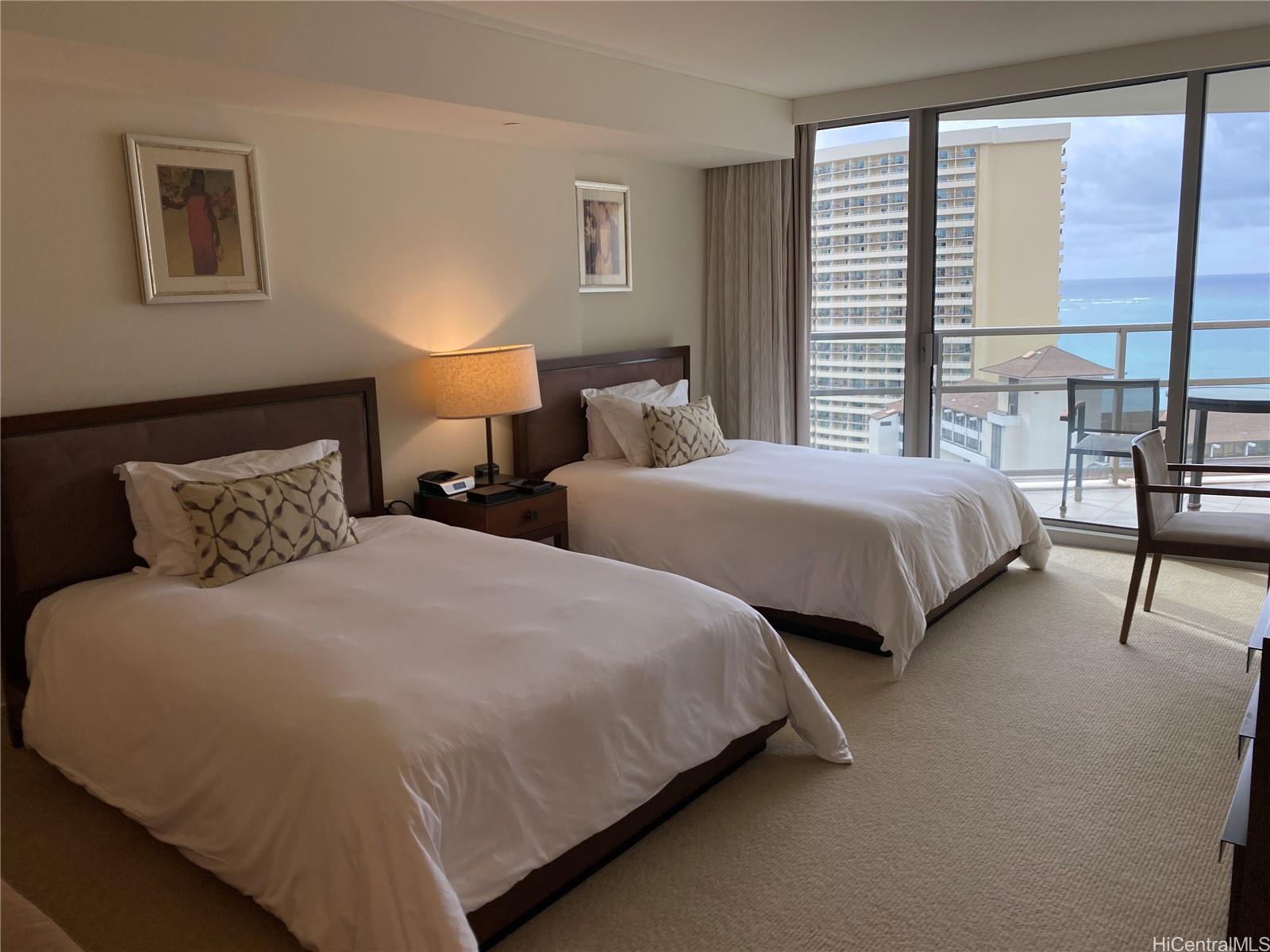 a bedroom with two beds and large window