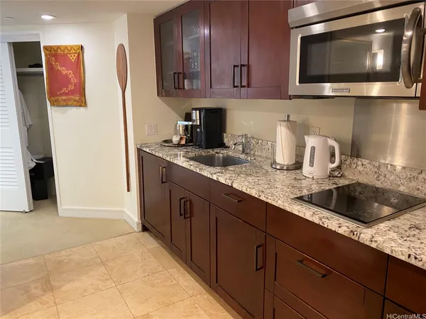 a kitchen with granite countertop a sink and a microwave