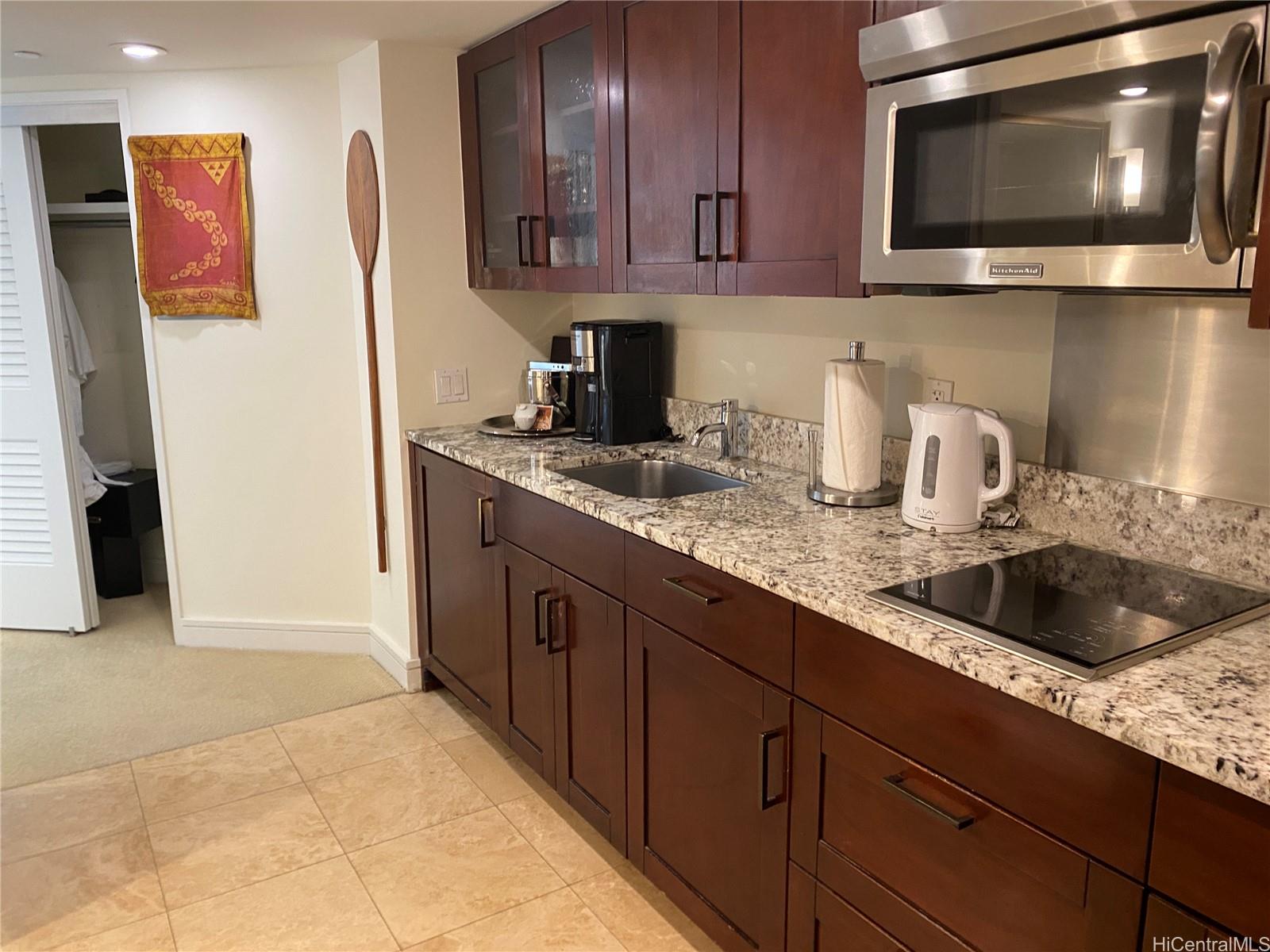 223 Saratoga Road, Unit 2220 Honolulu, HI 96815 - Photo 3 of 15 a kitchen with granite countertop a sink and a microwave