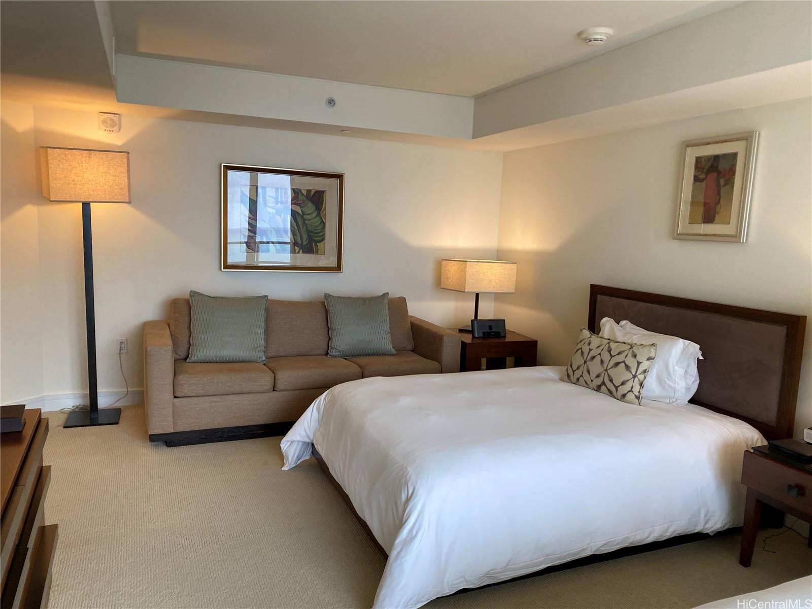 223 Saratoga Road, Unit 2220 Honolulu, HI 96815 - Photo 5 of 15 a bedroom with a bed and a lamp