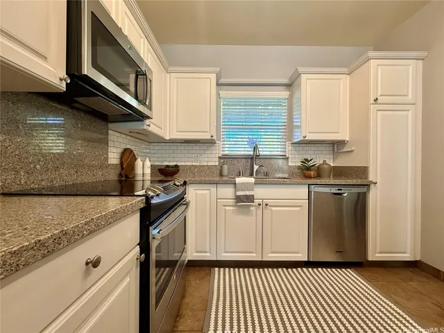 a kitchen with stainless steel appliances granite countertop a stove a sink and a microwave