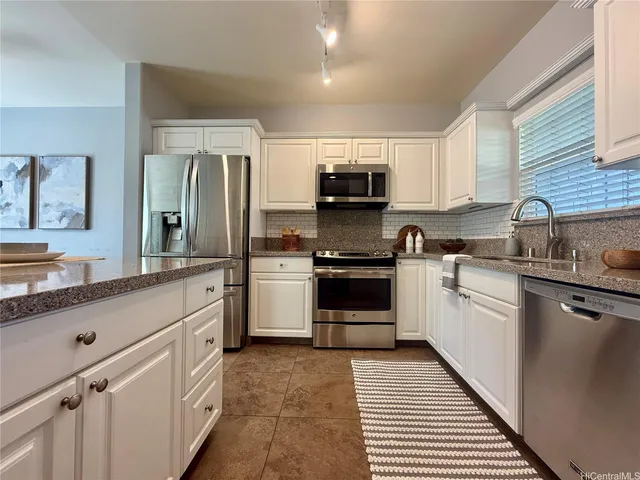 a kitchen with kitchen island white cabinets appliances and sink