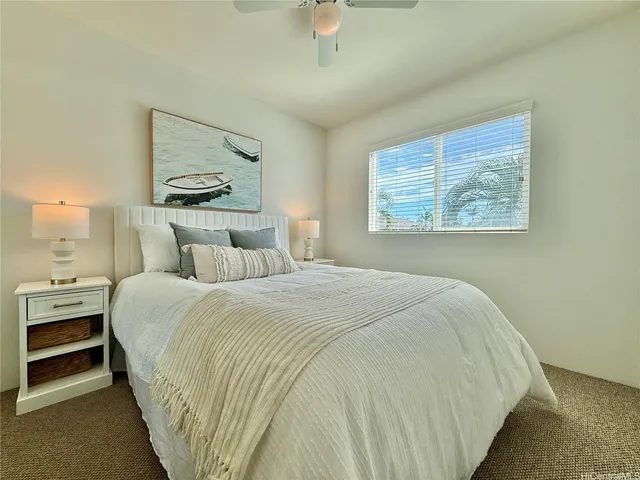 a bedroom with bed and paintings on the wall