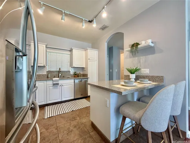 a kitchen with white cabinets and stainless steel appliances