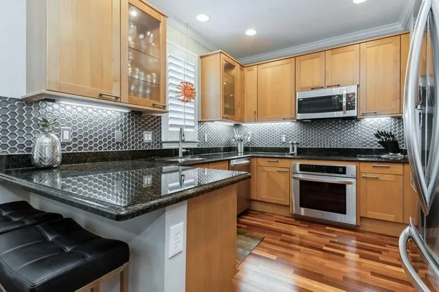 a kitchen with stainless steel appliances granite countertop a refrigerator a sink and a stove