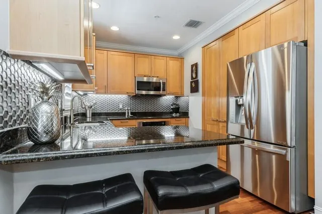 a kitchen with stainless steel appliances granite countertop a sink stove and microwave