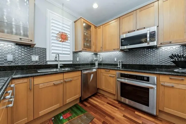a kitchen with stainless steel appliances granite countertop a sink stove and cabinets