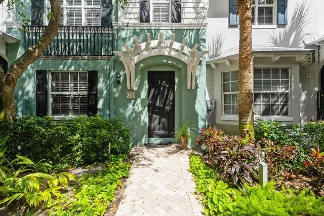 an entrance of a building with a lot of flower plants