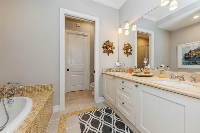 a spacious bathroom with a double vanity sink a mirror and a bathtub