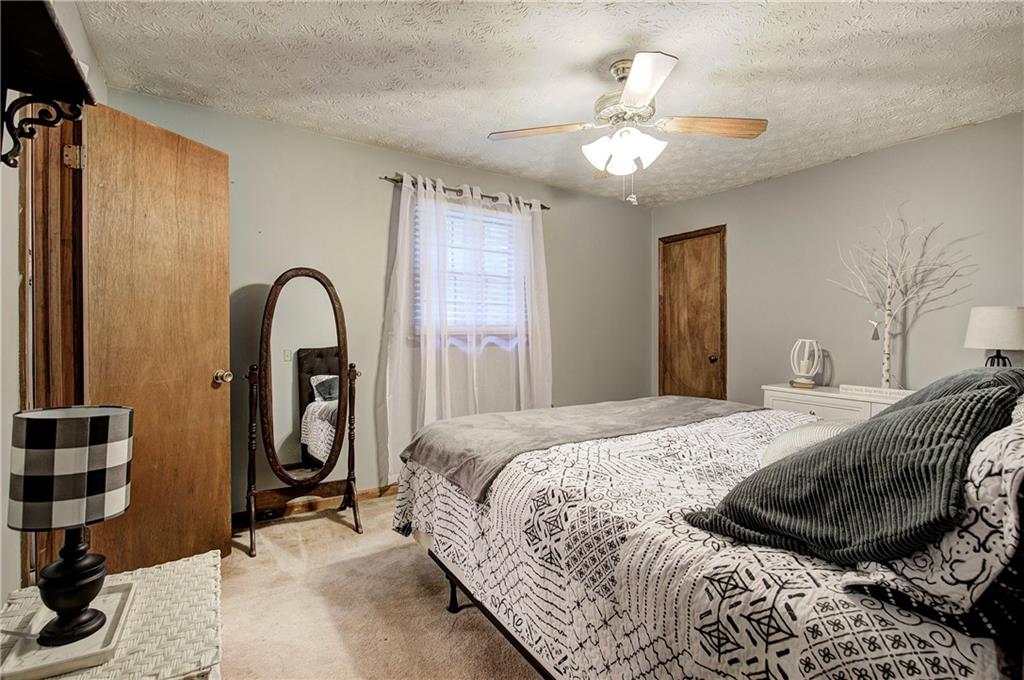 3637 Nebo Road Hiram, GA 30141 - Photo 49 of 63 a spacious bedroom with a bed and a chandelier