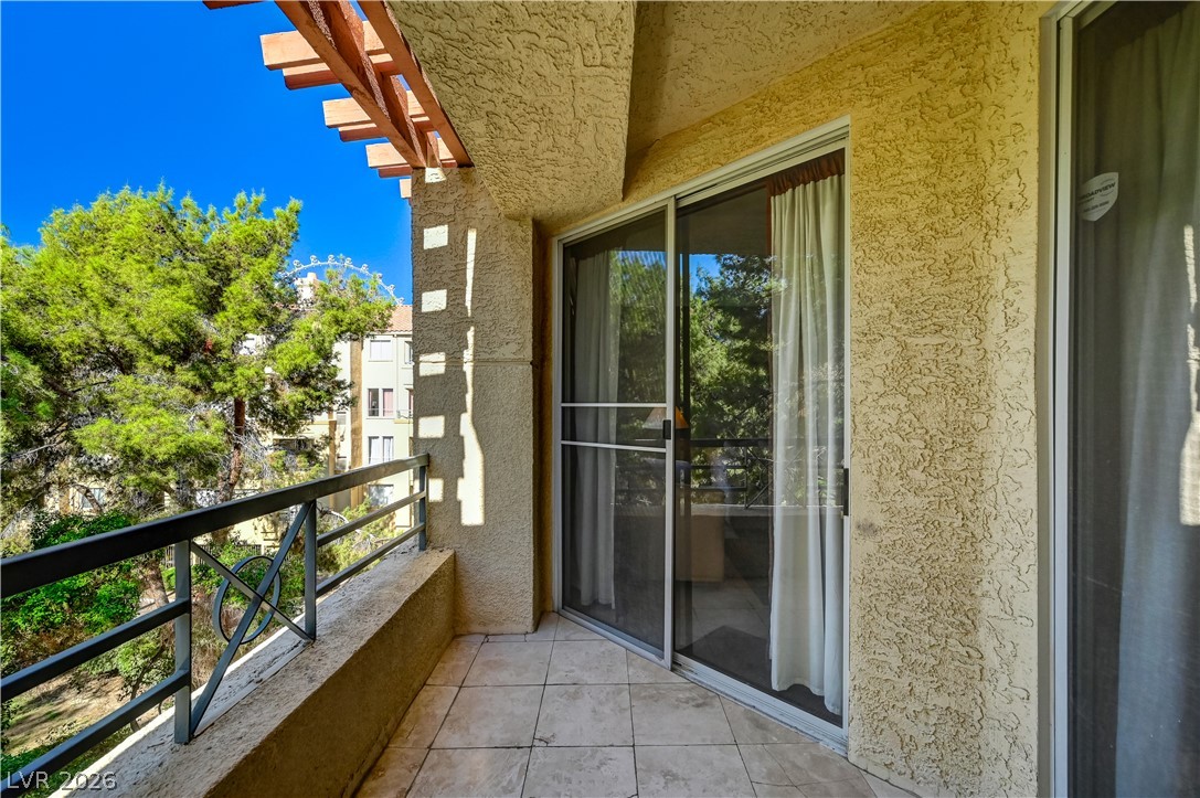 230 East Flamingo Road, Unit 333 Las Vegas, NV 89169 - Photo 36 of 61 Sliding glass doors open onto a private tiled balcony framed by classic stucco finishes.