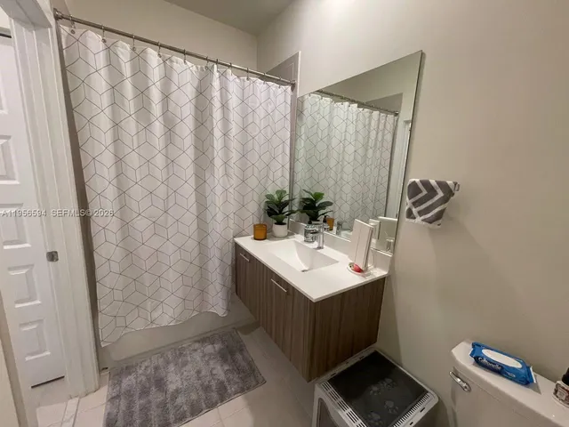 a bathroom with a sink a mirror and a shower curtain