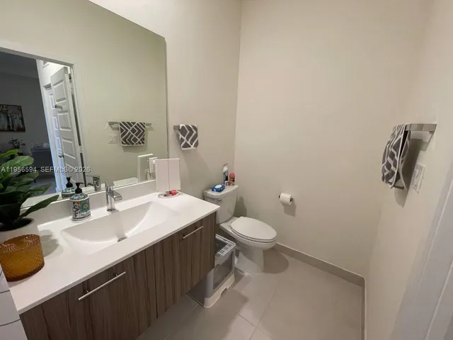 a bathroom with a sink mirror vanity and toilet
