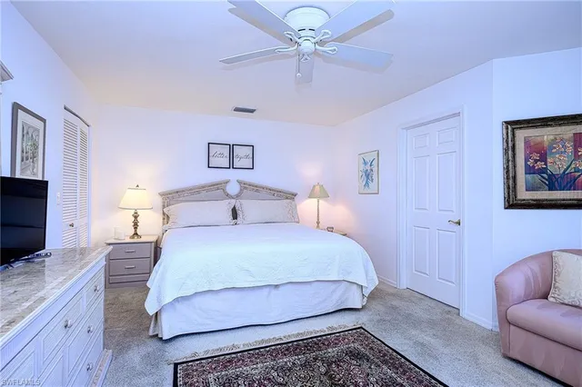 a bedroom with a bed and a flat tv screen on dresser