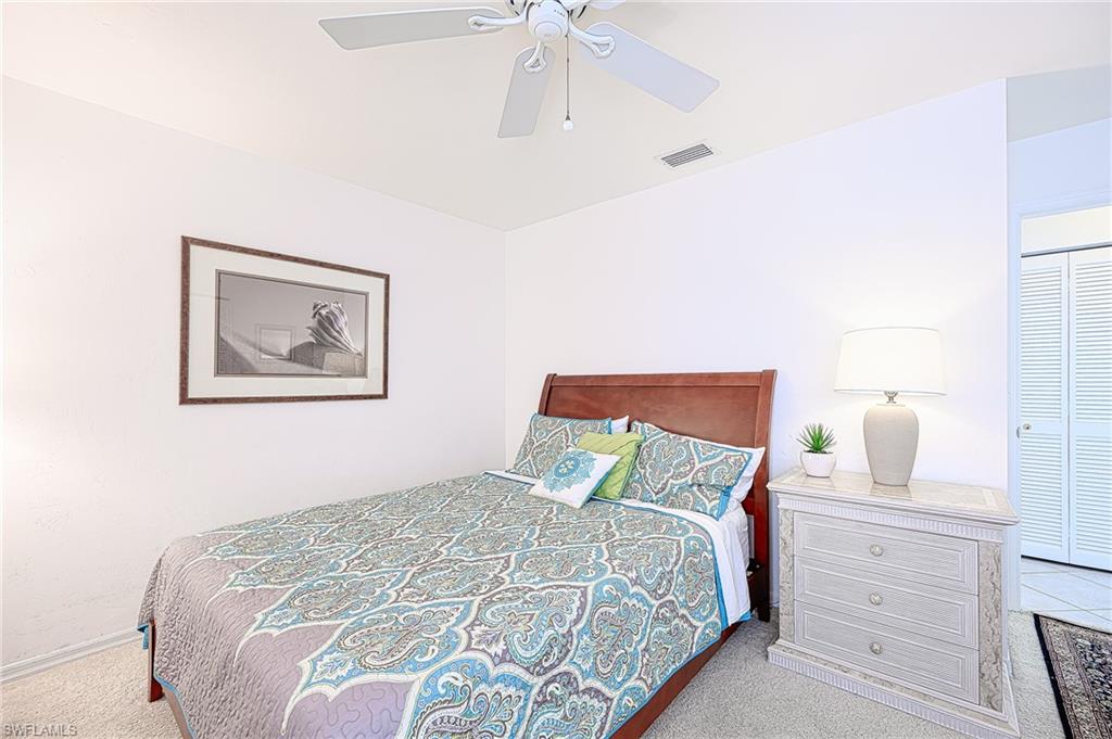 613 Beachwalk Circle Naples, FL 34108 - Photo 20 of 47 a bedroom with a bed and a chandelier