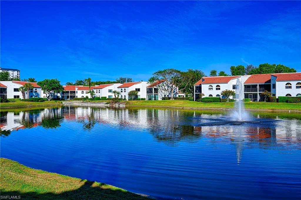 613 Beachwalk Circle Naples, FL 34108 - Photo 3 of 47 a view of a lake with houses in the background