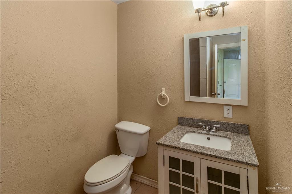 21440 Sunflower Road Edinburg, TX 78542 - Photo 12 of 25 a bathroom with a granite countertop toilet and a sink