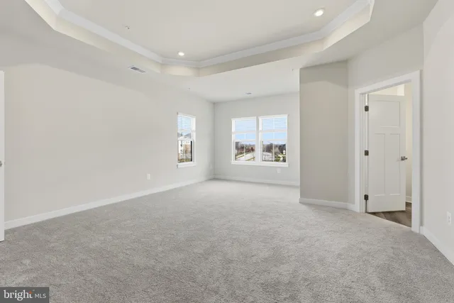 a view of a big room with windows and chandelier fan
