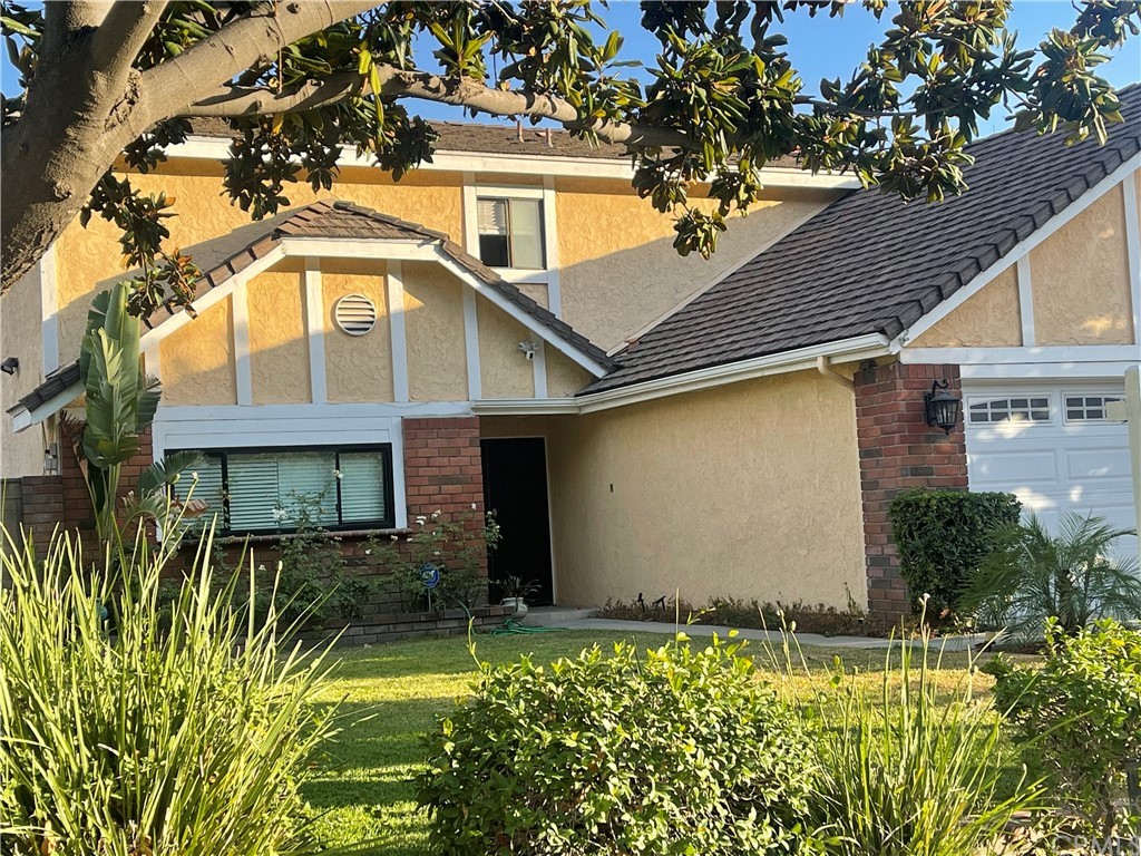 a front view of house along with deck and garden