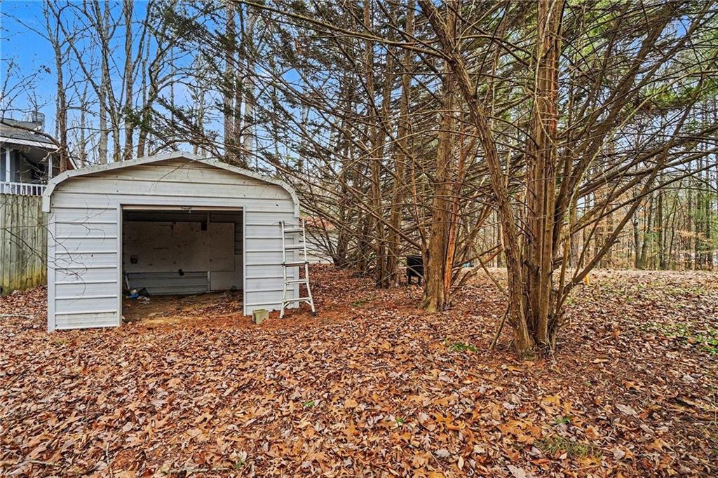 1497 Harris Road Jasper, GA 30143 - Photo 22 of 32 a backyard of a house with large trees and brick wall