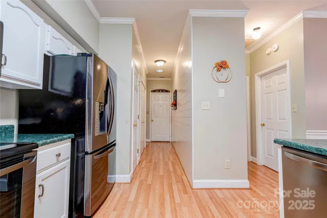 a view of a kitchen with refrigerator and wooden floor