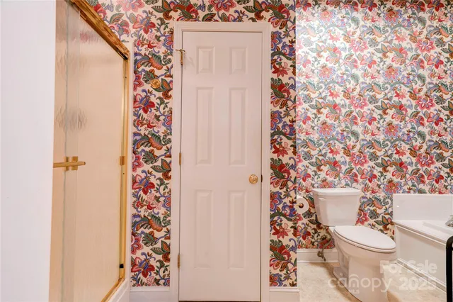 a white toilet sitting next to a shower curtain