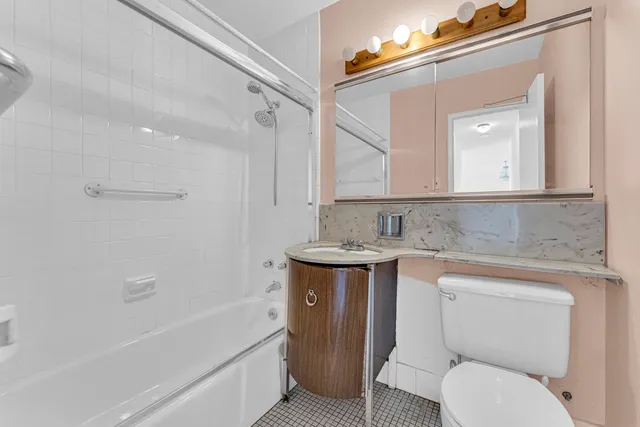 a bathroom with a granite countertop sink toilet and shower