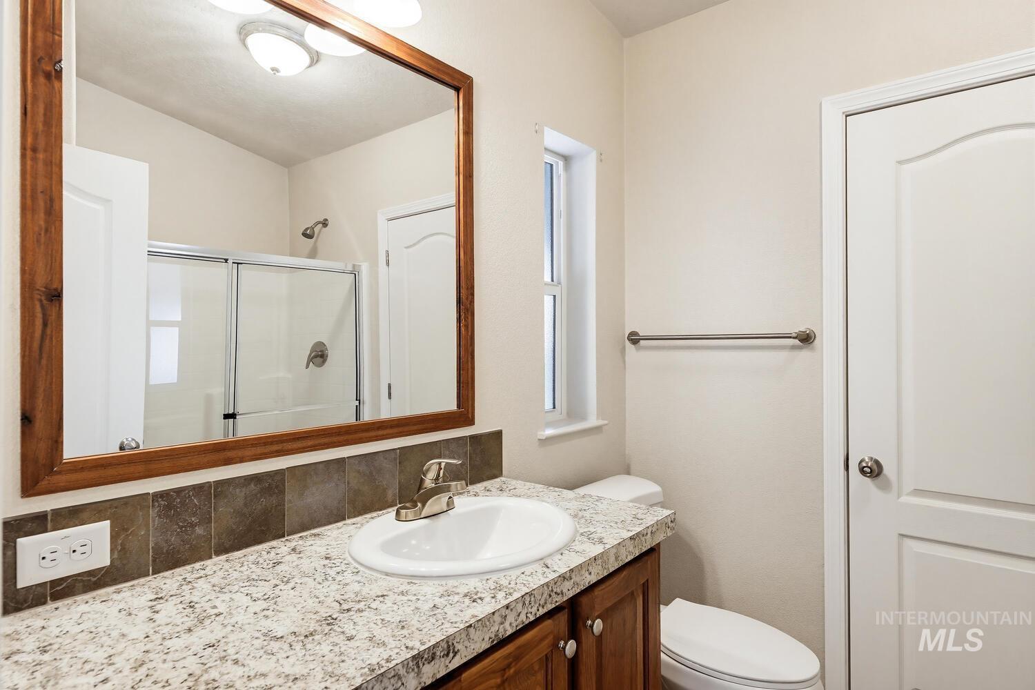 166 1st Street North Marsing, ID 83639 - Photo 18 of 37 Bathroom featuring vanity, a stall shower, and decorative backsplash