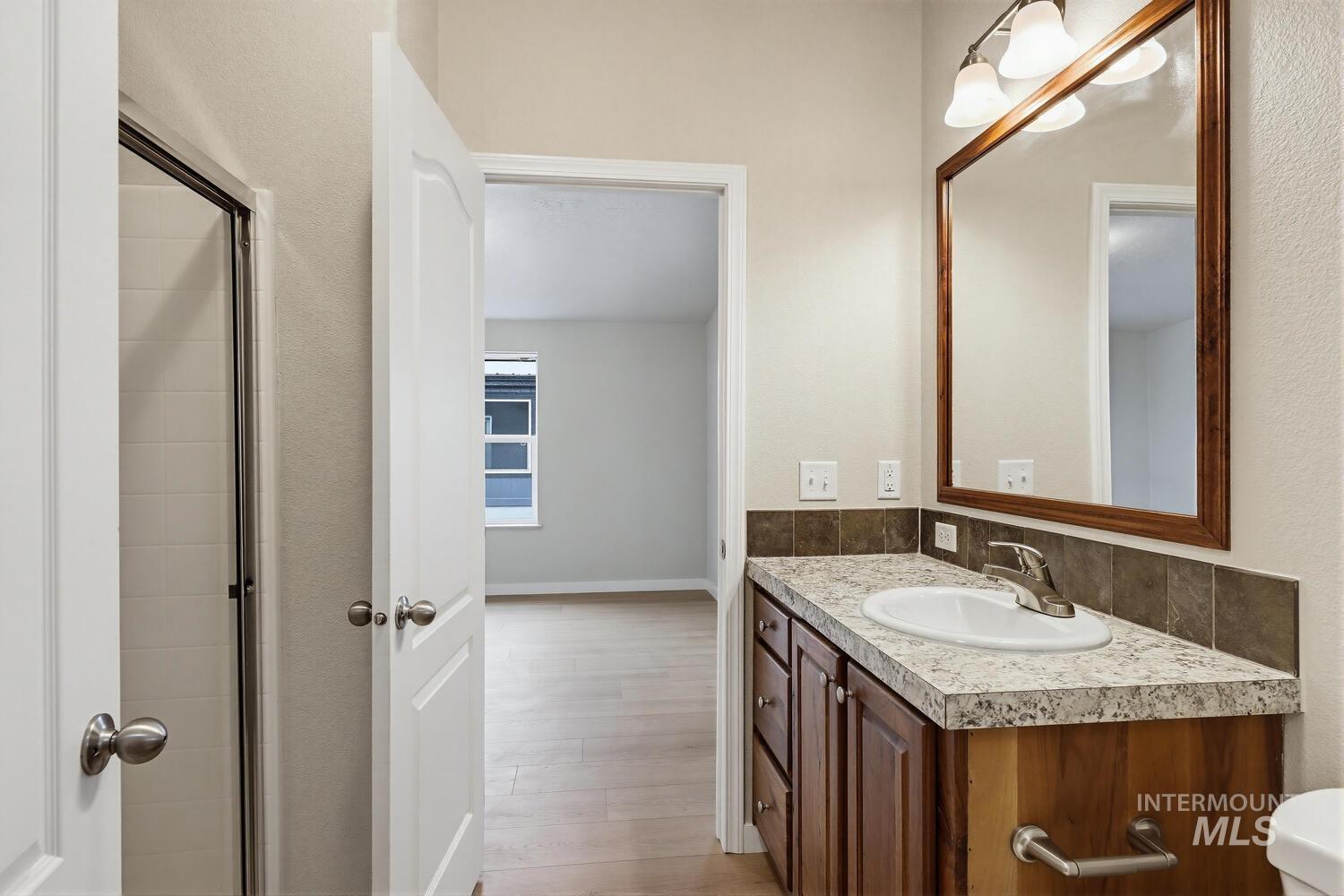 166 1st Street North Marsing, ID 83639 - Photo 19 of 37 Bathroom featuring vanity, light wood-style flooring, and a stall shower