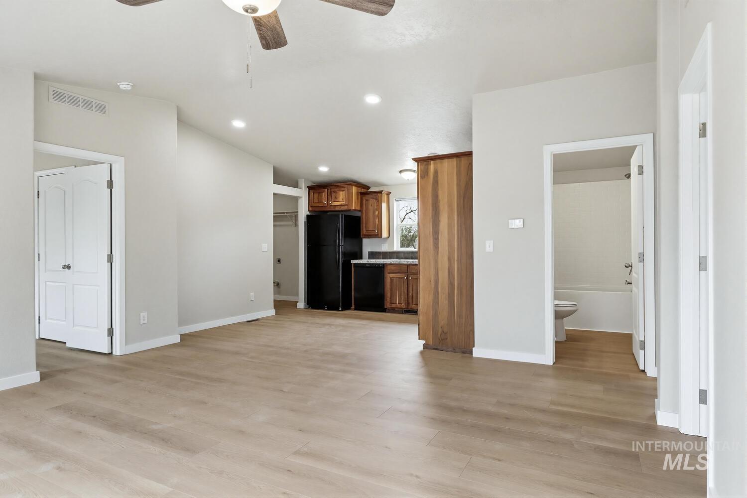 166 1st Street North Marsing, ID 83639 - Photo 8 of 37 Kitchen featuring ceiling fan, light countertops, wood finish cabinetry, black appliances, and light wood finished floors