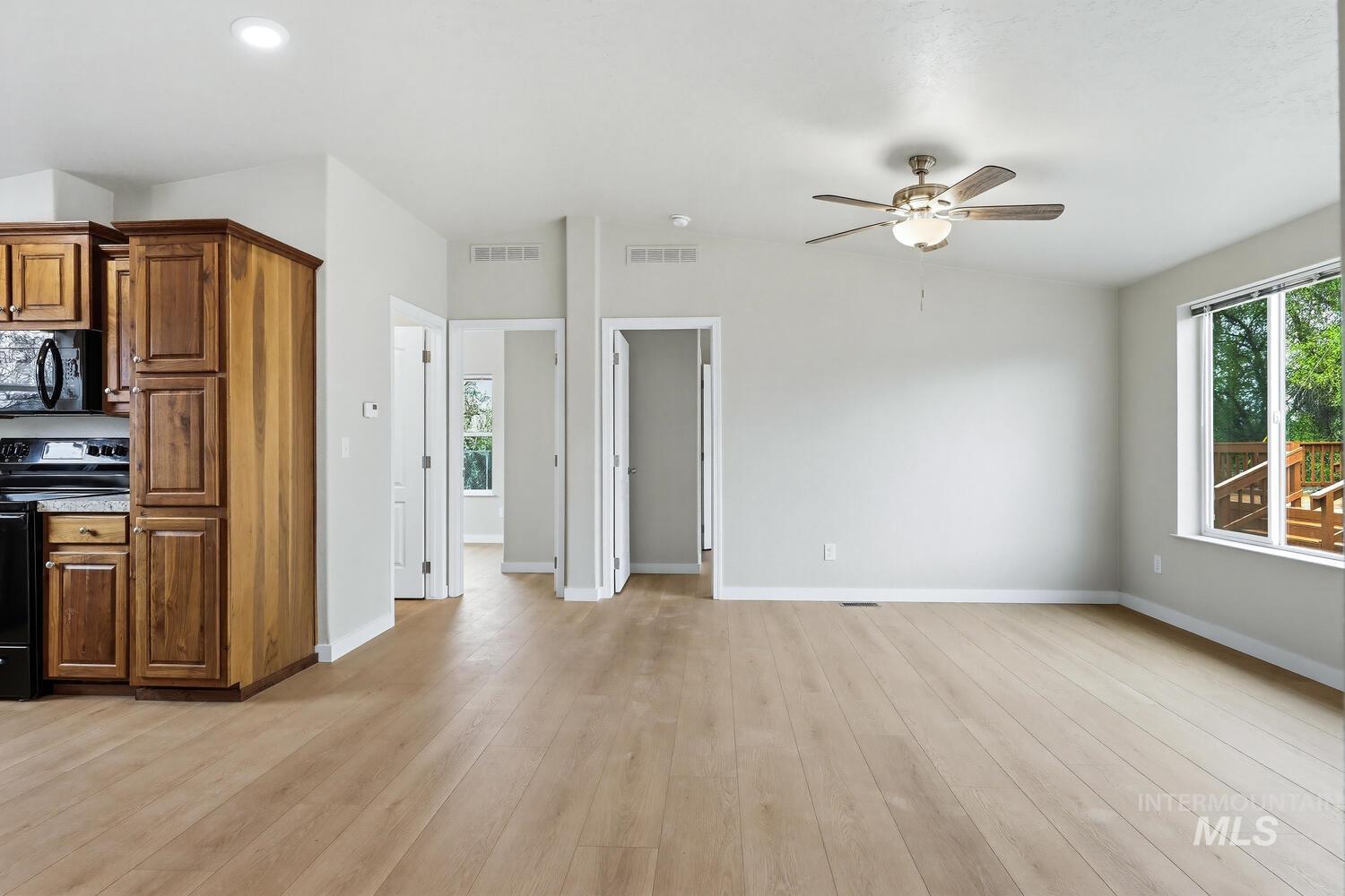 166 1st Street North Marsing, ID 83639 - Photo 9 of 37 Kitchen with electric range, wood finish cabinetry, black microwave, a ceiling fan, and light wood finished floors