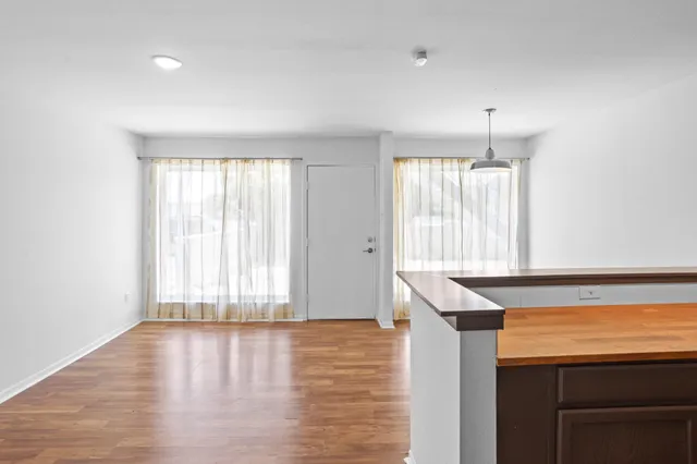 a view of a kitchen with wooden floor and a window