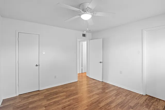a view of an empty room with wooden floor