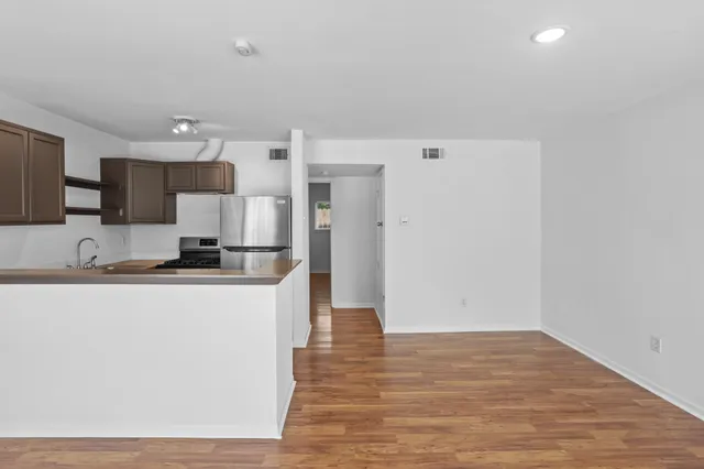 a kitchen with granite countertop a refrigerator and a stove top oven