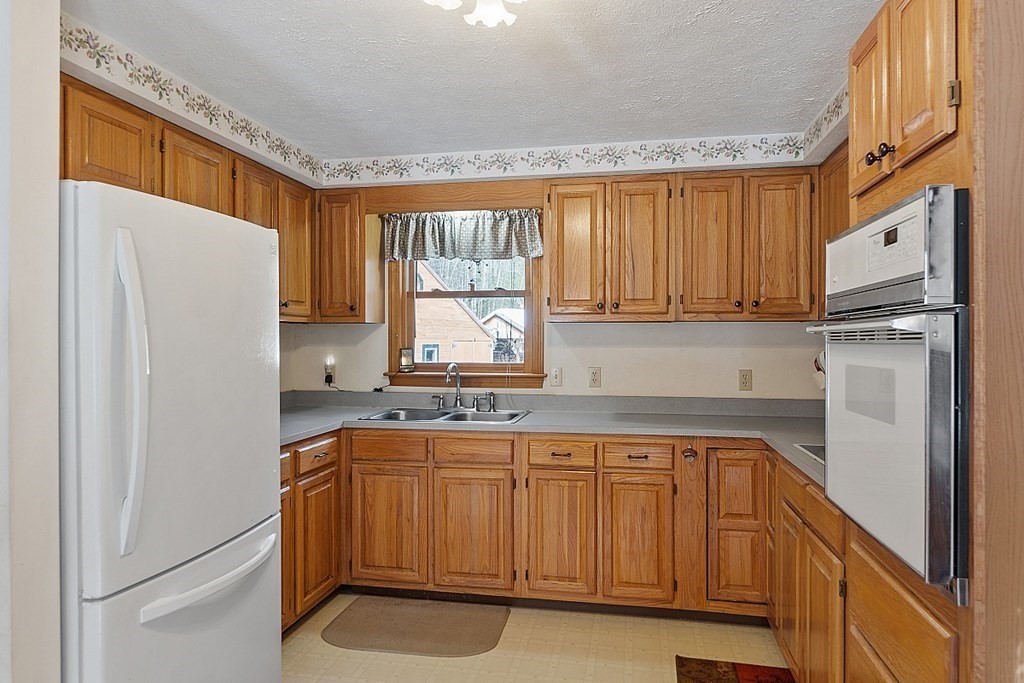 864 Foster Road Ashby, MA 01431 - Photo 14 of 41 a kitchen with a refrigerator a sink and cabinets